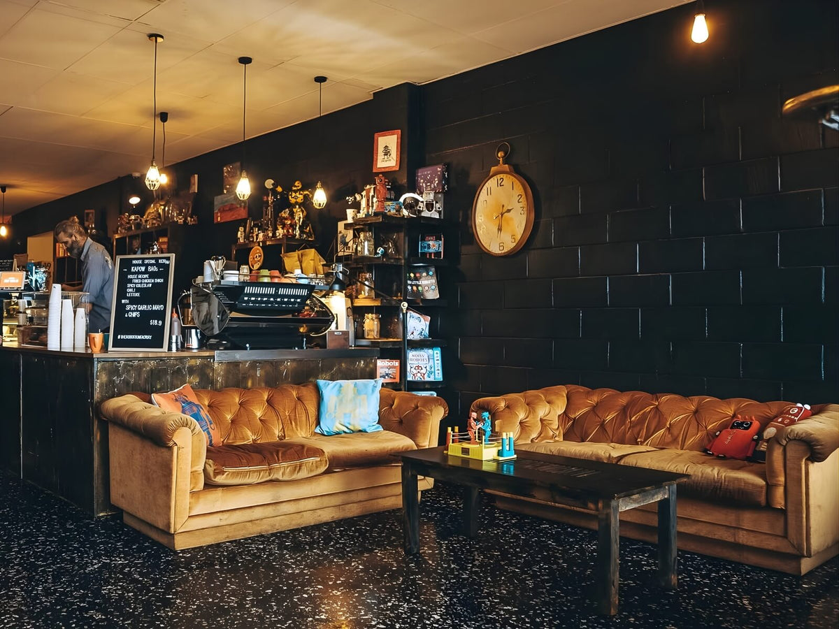 Robot Bun Factory cafe interior with vintage sofas, dark walls and warm pendant lighting